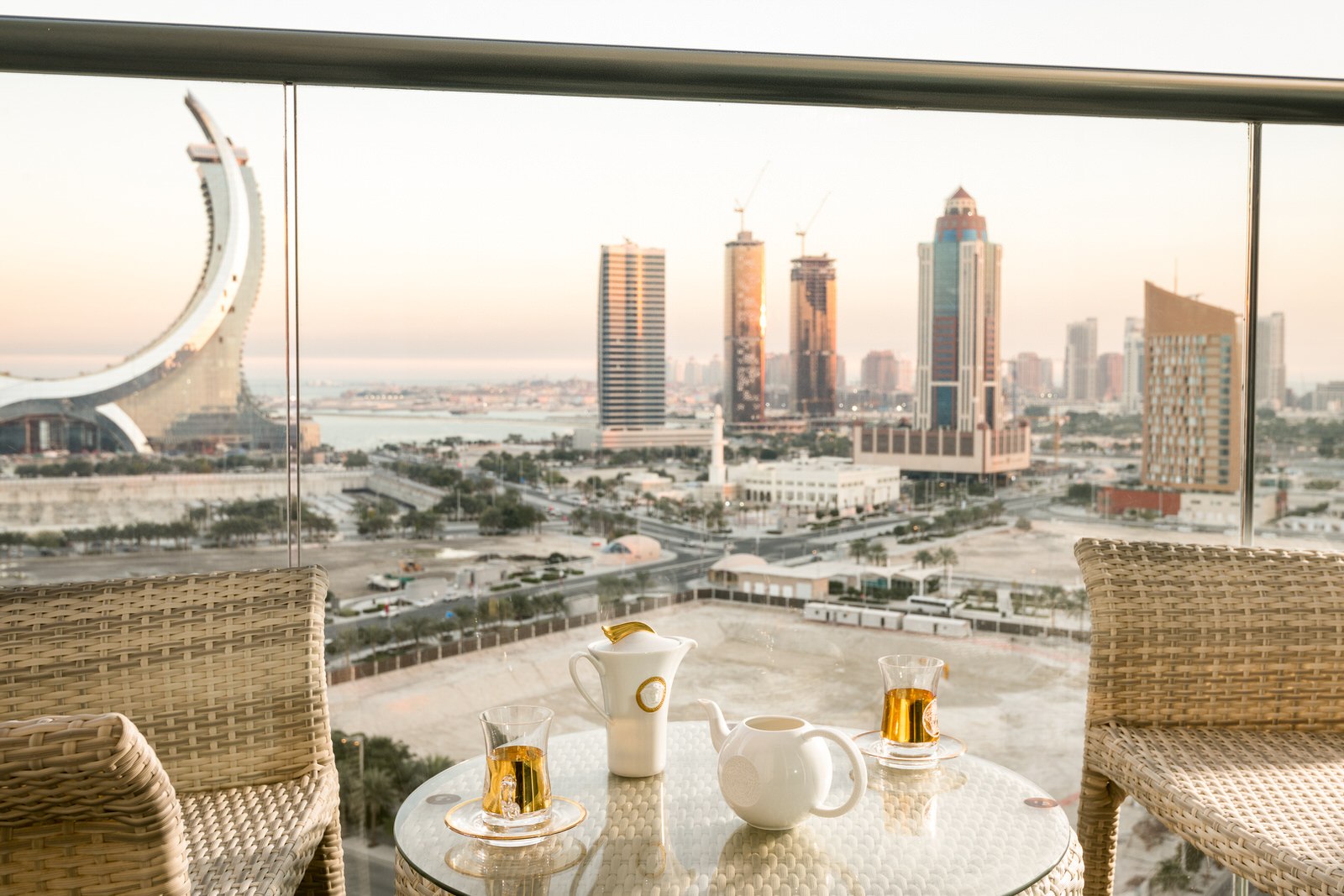 A peaceful balcony setup with a table and two chairs, ideal for enjoying tea and the beautiful Doha view.