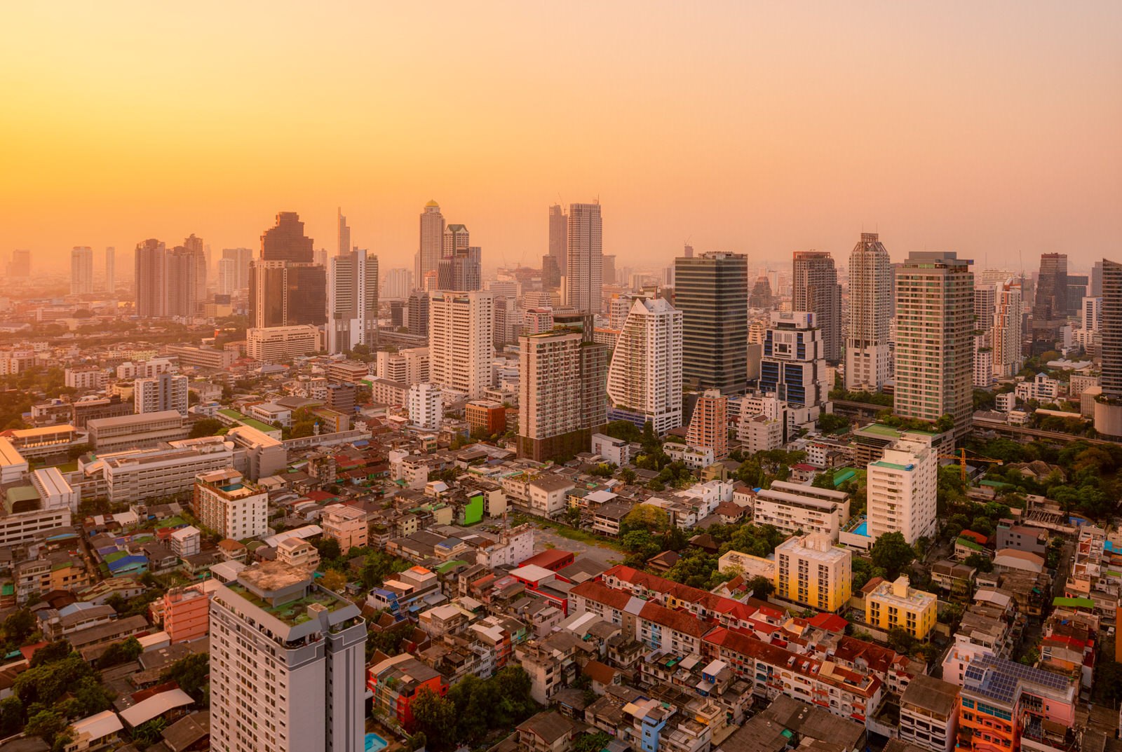 Bangkok skyline at sunset, showcasing vibrant colors and silhouettes of skyscrapers against the evening sky.